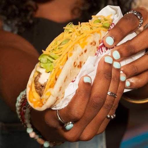 Hands holding a taco from Taco Bell