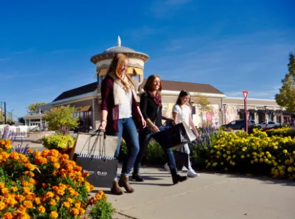 Shoppers walk through the Promenade Shops at Centerra in Loveland on a sunny morning.