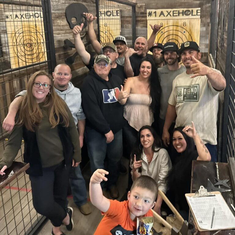People pose for a photo in an axe throwing stall