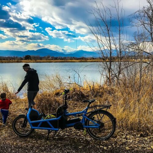 A father and son stand by a pond at River's Edge Natural Area in Loveland.