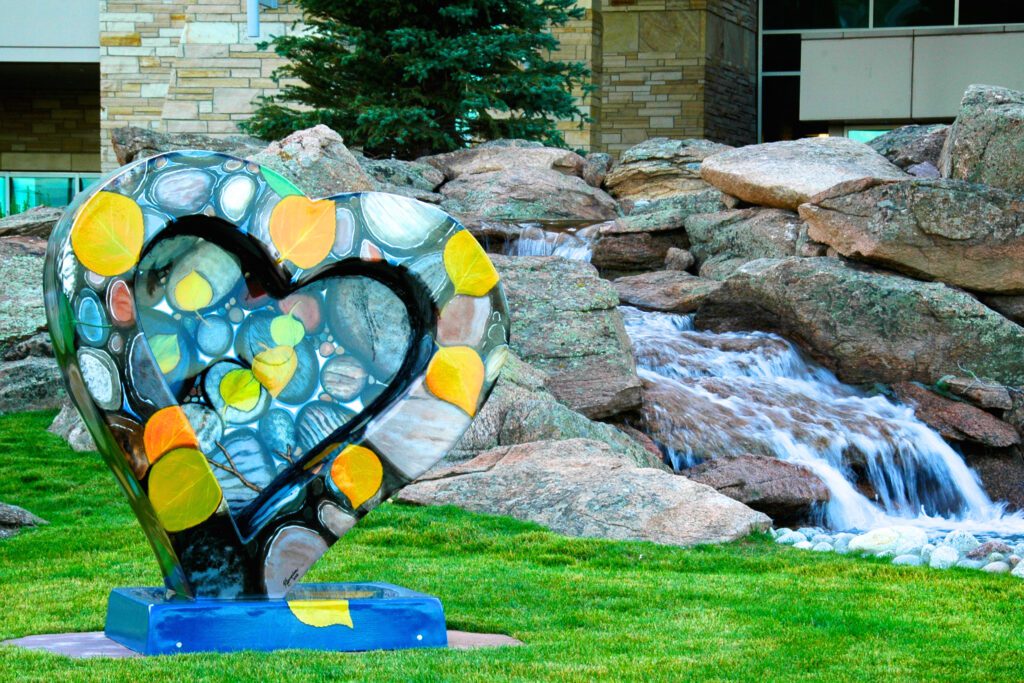 Heart Sculpture in the grass near a waterfall at a Loveland business.