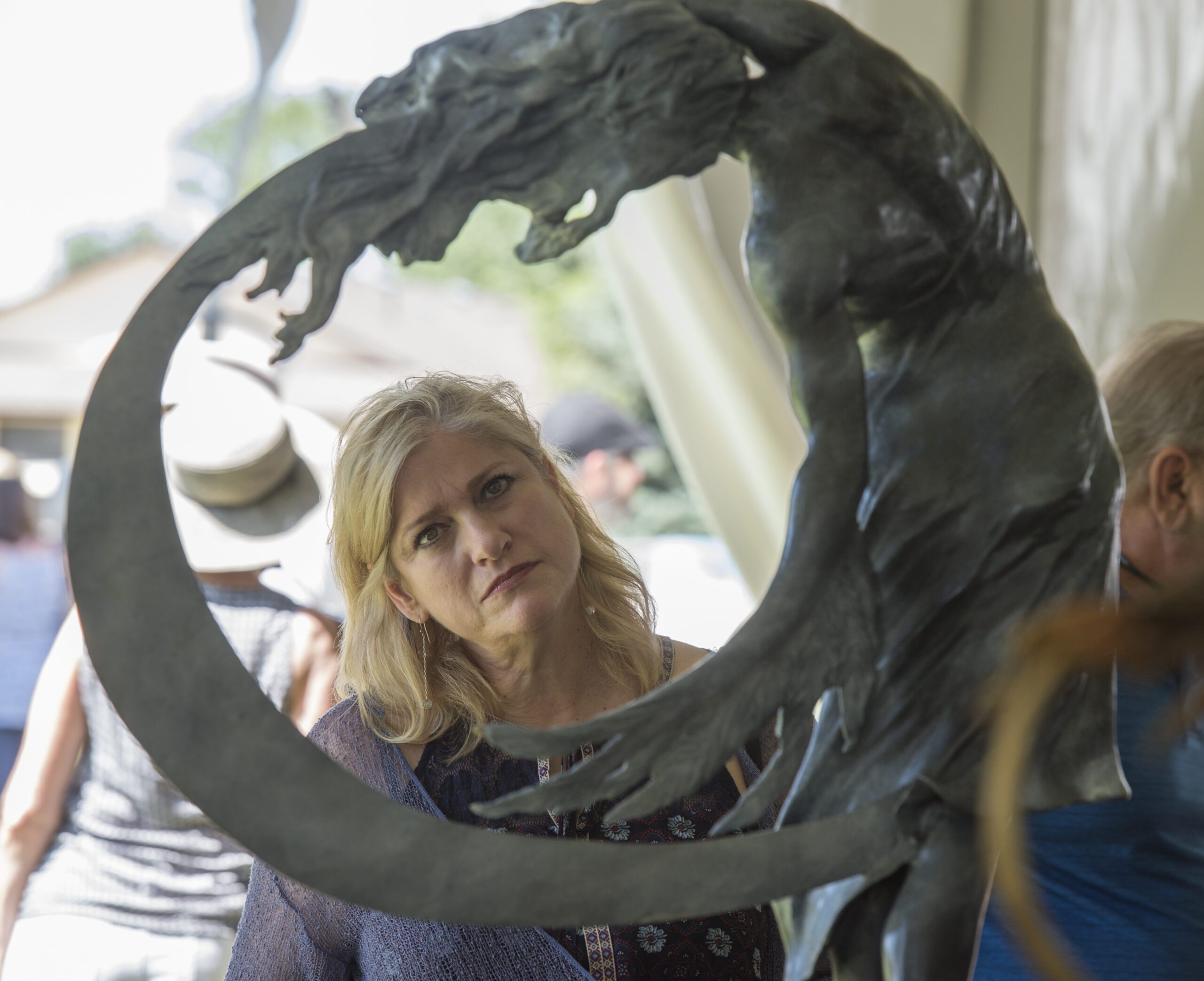 A woman examines a sculpture at Loveland, Colorado's Sculpture in the Park event.