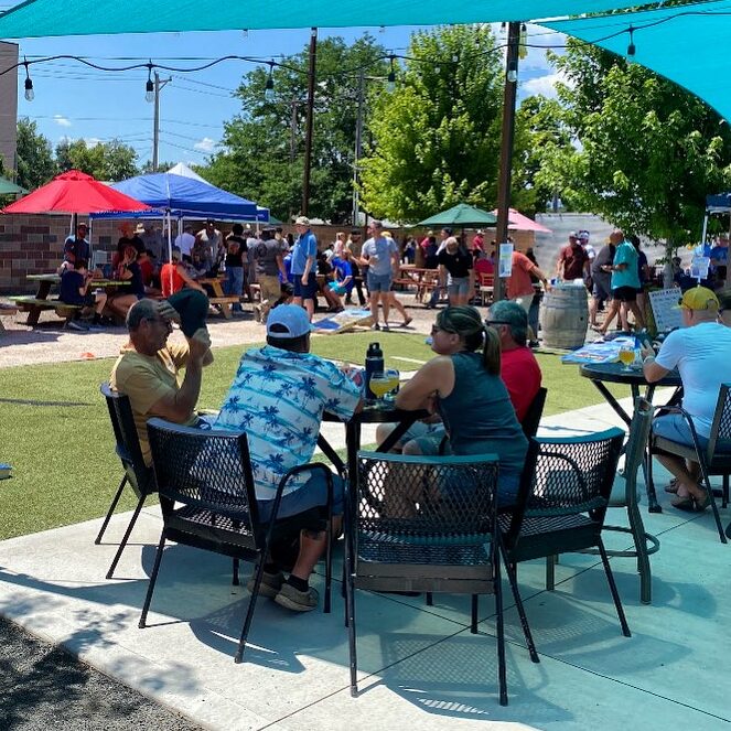 People enjoy the patio at Backyard Tap on a warm, sunny day.