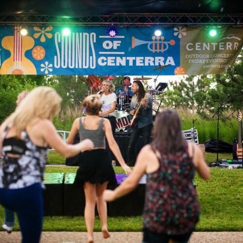 People dance on the great lawn at Chapungu Sculpture Garden for Sounds of Centerra concerts