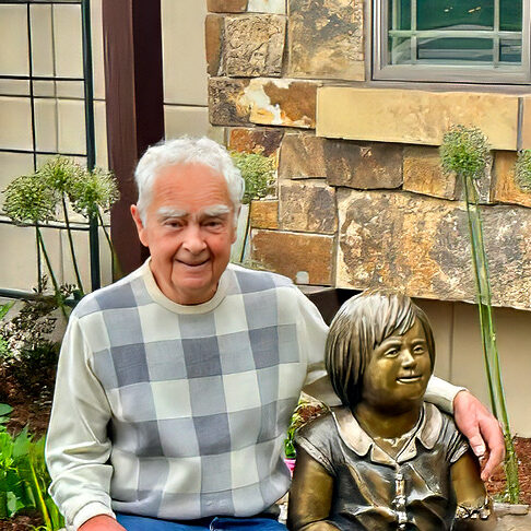 George Walbye sits with one of his sculptures.