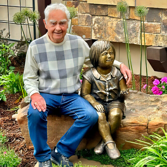 George Walbye sits with his sculpture Marilee