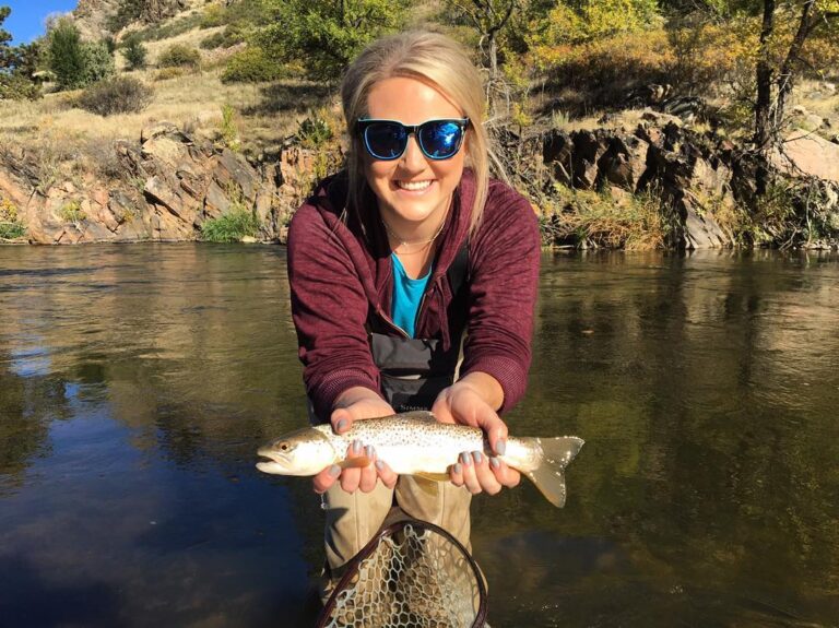 A woman holds a trout in the Big Thompson River.