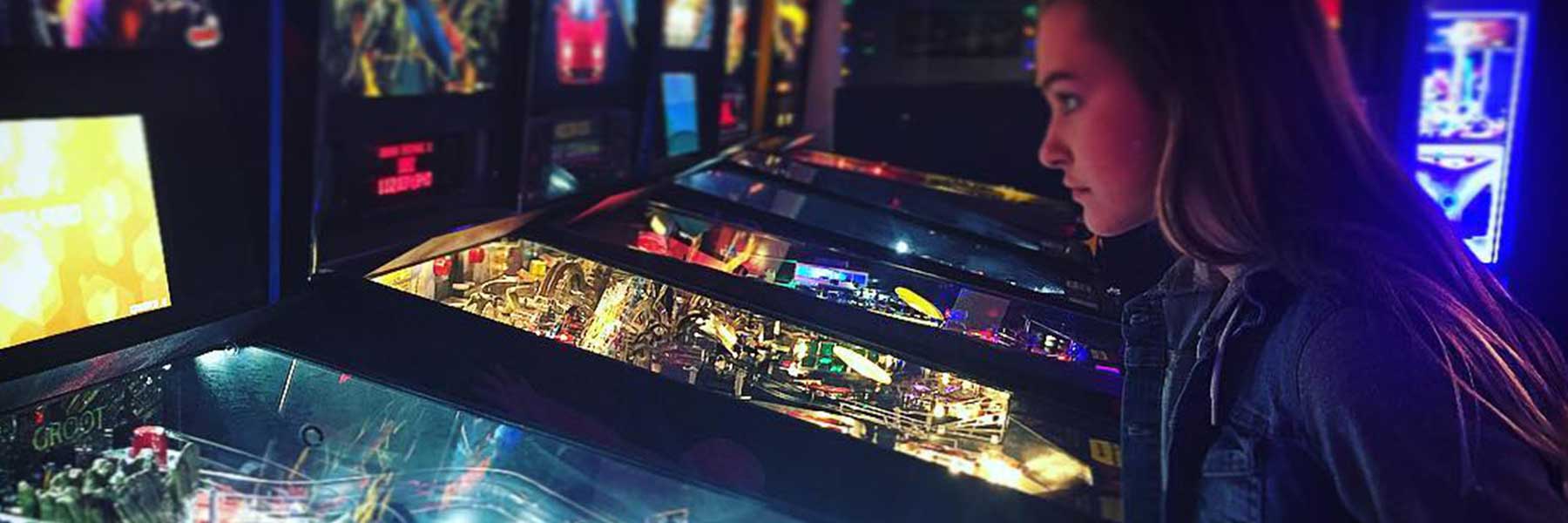 Girl playing pinball in Loveland, Colorado