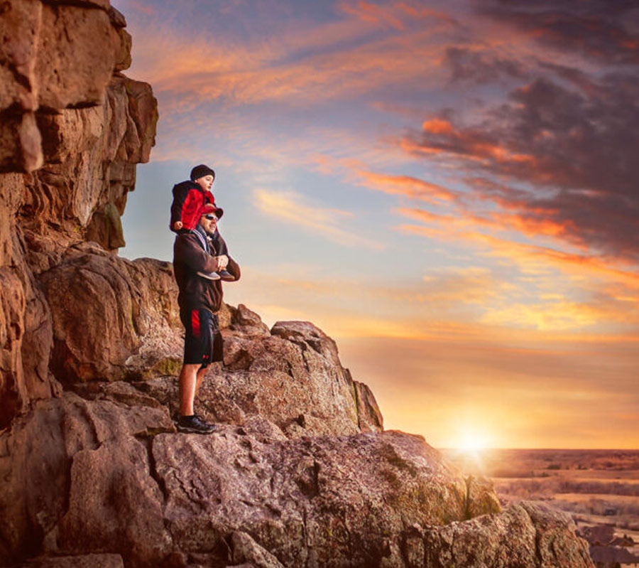 A man which a child on his shoulders, looking at the sunset in Loveland, Colorado