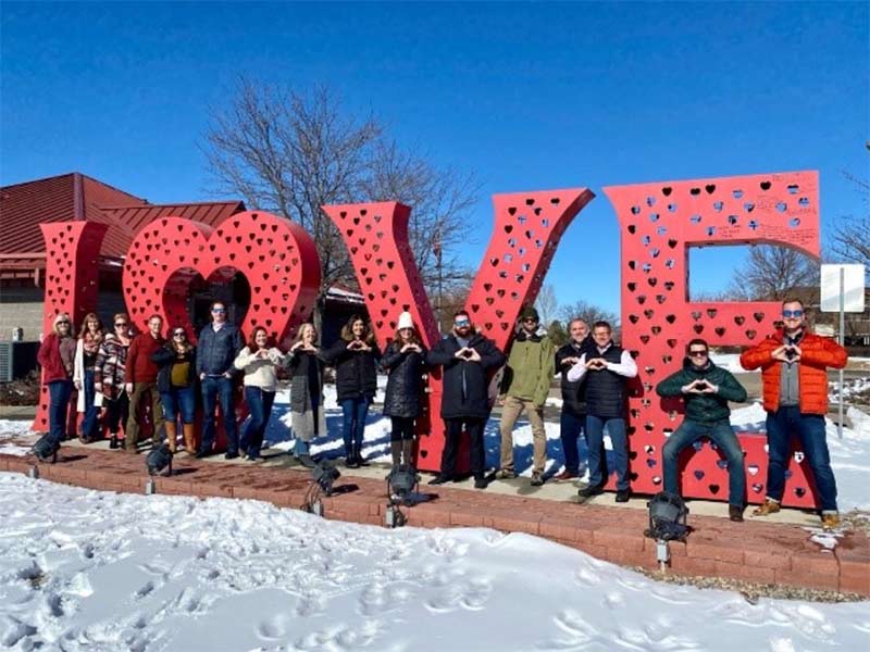 Group of people posing in front of Loveland, Colorado's Love Lock Sculpture