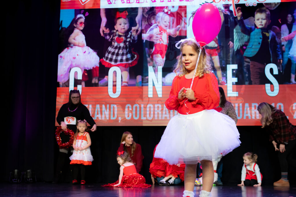 Little girls dressed up for Valentines Day on stage.