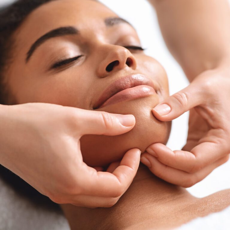 A woman enjoys a face massage.