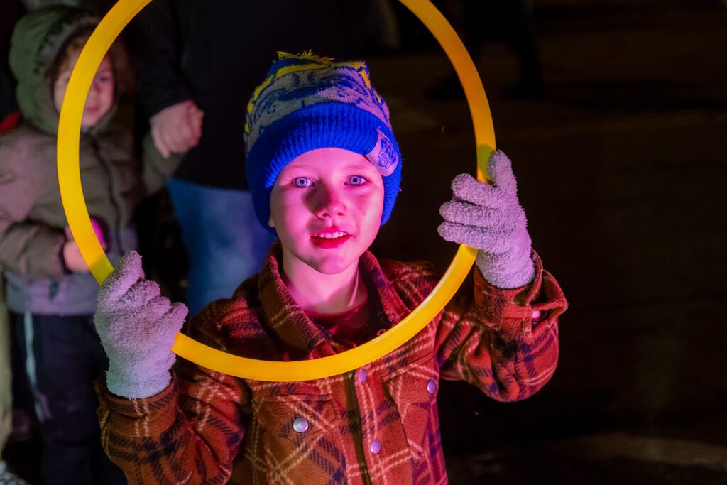 A child holds up a ring from the Penguin Ring toss game at the 2024 Loveland Sweetheart Festival.