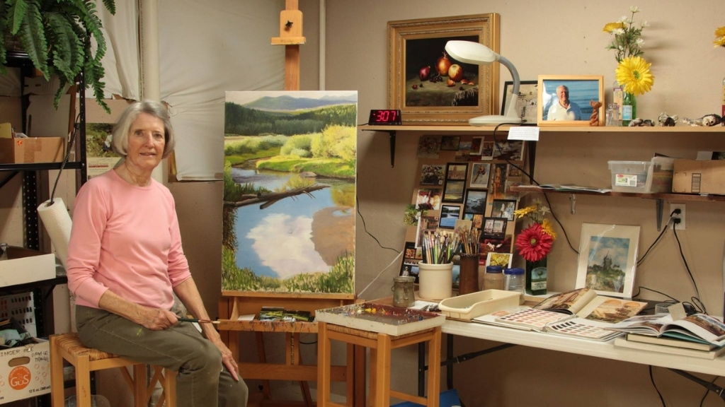 Artist painting inside a working studio during the Loveland Art Studio Tour in Loveland, Colorado.