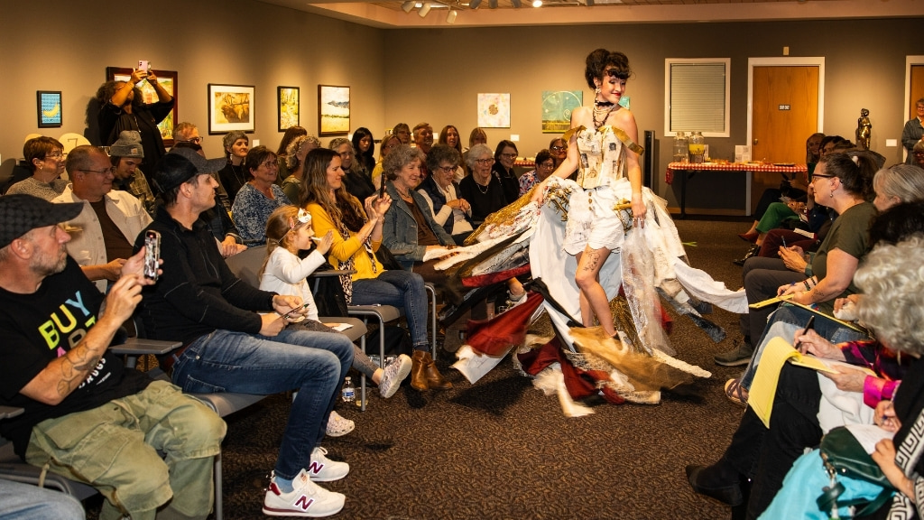 Model walks the Trash Fashion Show runway in Loveland, Colorado, wearing a dress made from recycled materials.