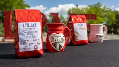 Bags of coffee and ceramic coffee cups on display at teh Loveland Visitors Center